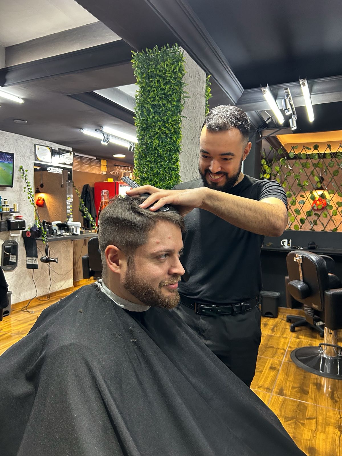 Barbeiro finalizando um corte masculino